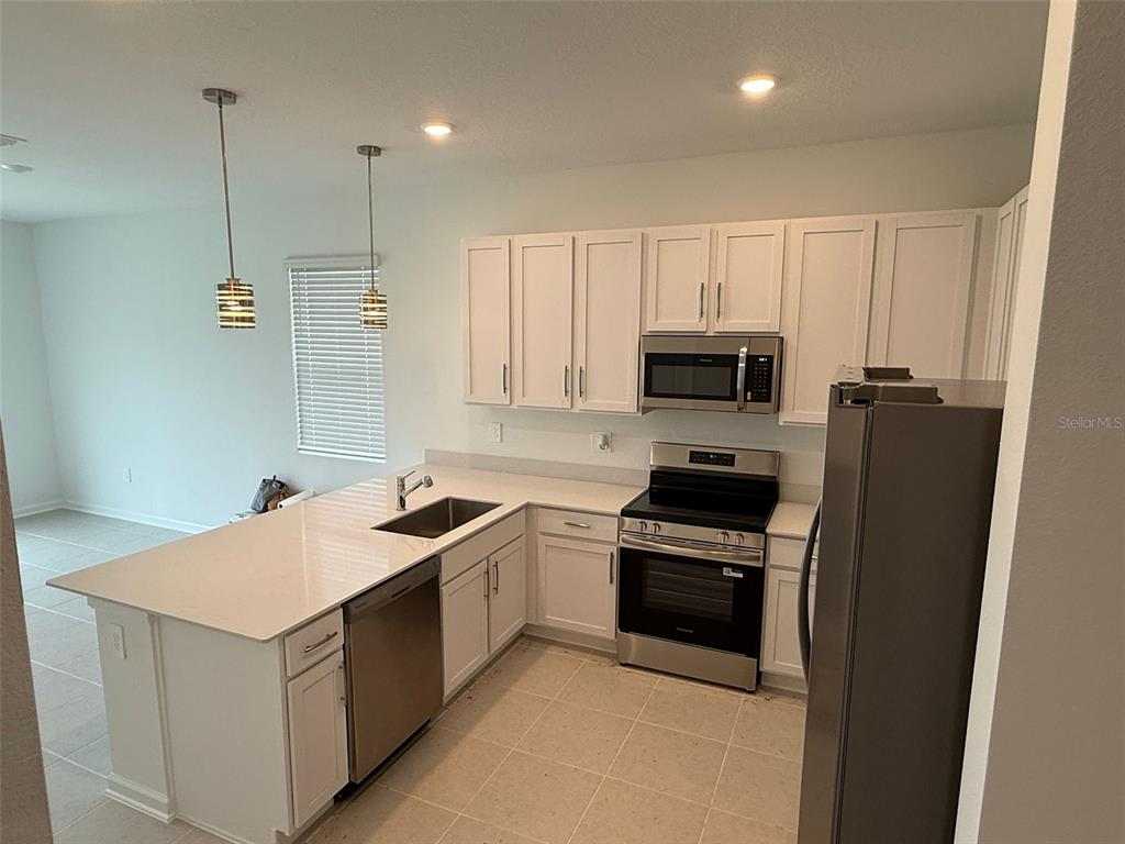 2691 Skyline Loop Kissimmee, FL 34758 - Photo 6 of 27 a kitchen that has a sink a stove oven and a refrigerator