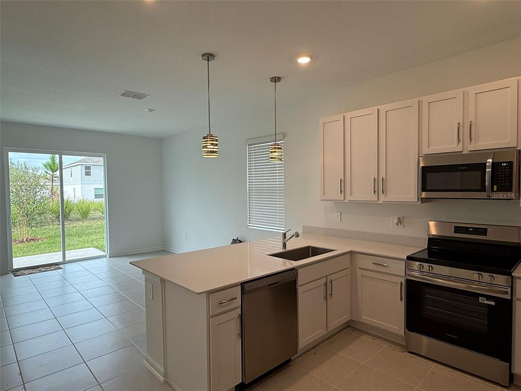 2691 Skyline Loop Kissimmee, FL 34758 - Photo 7 of 27 a kitchen that has a sink a stove and cabinets