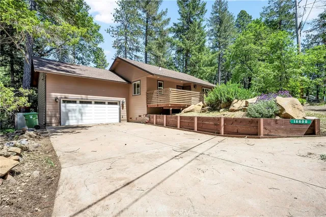 a backyard of a house with table and chairs under an umbrella