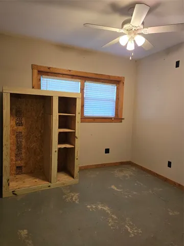 an empty room with closet and fan