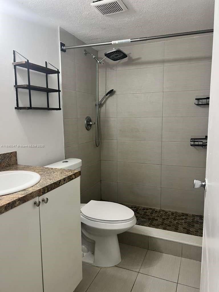 1875 West 56th Street, Unit 103 Hialeah, FL 33012 - Photo 12 of 13 a bathroom with a granite countertop toilet a sink and shower