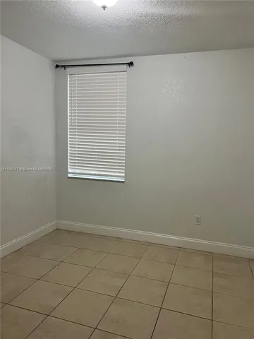 an empty room with a white cabinet and a window