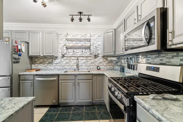 a kitchen with granite countertop a sink stove and cabinets
