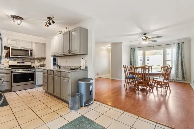 a kitchen with granite countertop a stove top oven a sink a dining table and chairs