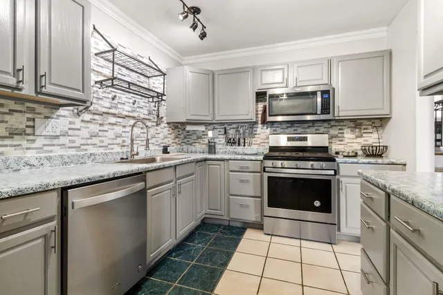 a kitchen with stainless steel appliances granite countertop a stove sink microwave and cabinets