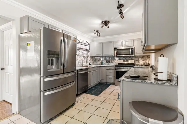 a kitchen with a sink stainless steel appliances and white cabinets