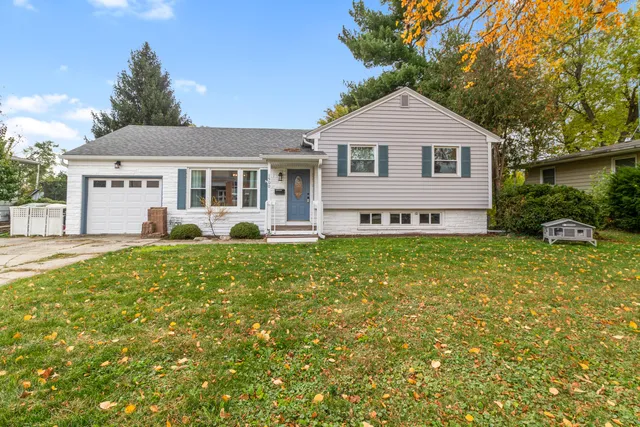 a front view of a house with a yard and potted plants