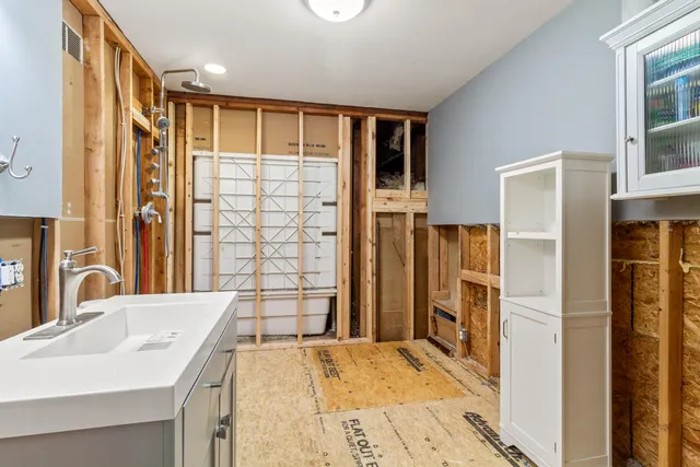 a bathroom with a sink shower and a mirror