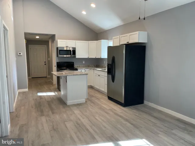a kitchen with stainless steel appliances a refrigerator and a stove top oven