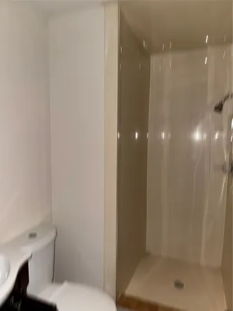 a bathroom with a shower a toilet and a sink