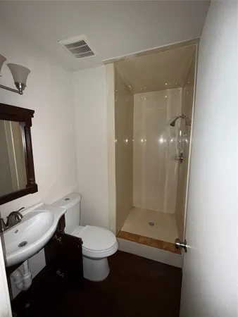 a bathroom with a toilet a sink and shower