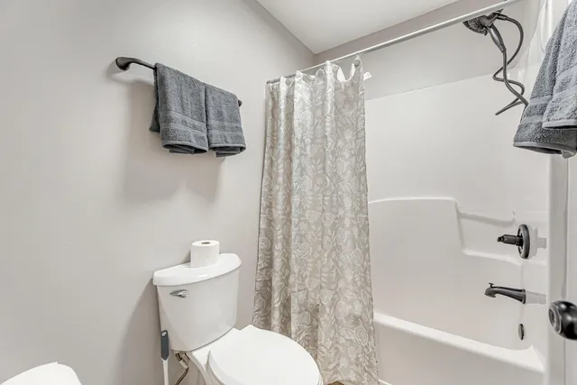 a white toilet sitting next to a bath tub shower