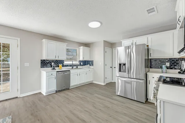 a kitchen with a refrigerator cabinets and wooden floor