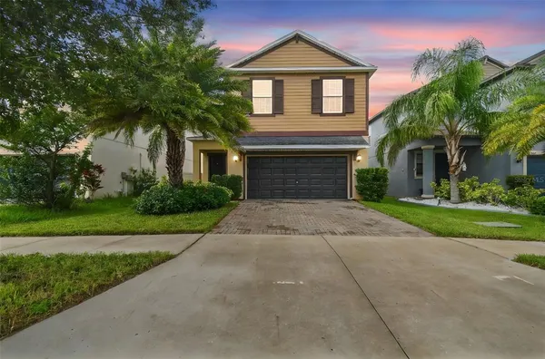 a front view of a house with a yard and a garage