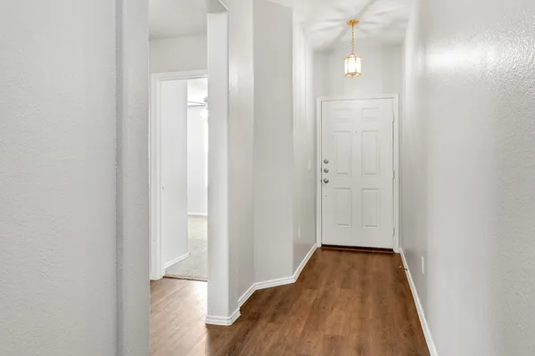 a view of a room with wooden floor and a bathroom