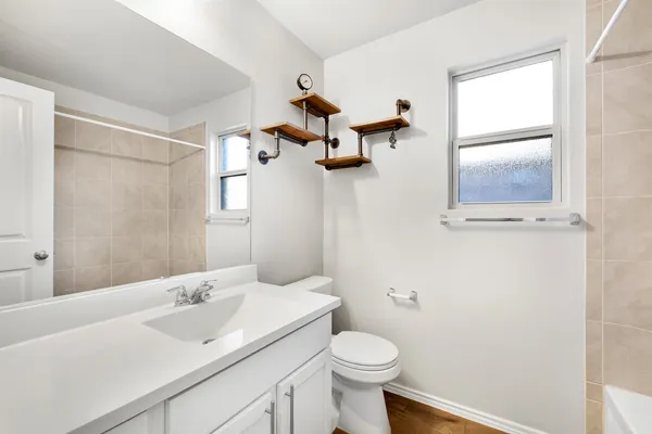 a bathroom with a sink vanity mirror and toilet