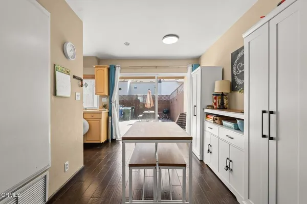 a kitchen with white cabinets and wooden floor
