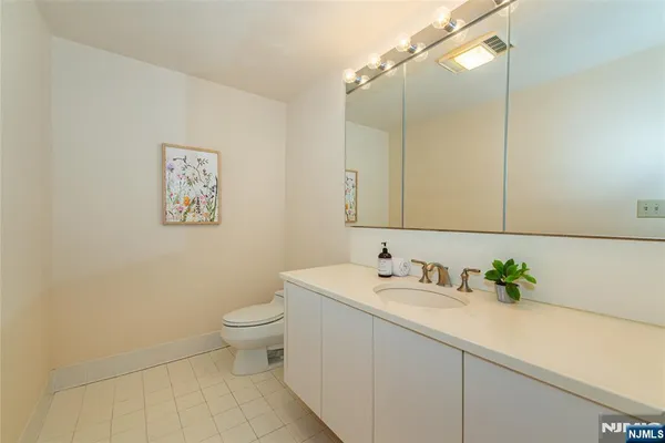a bathroom with a sink a toilet and mirror