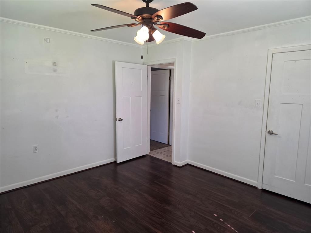 103 North Magnolia Street Plain Dealing, LA 71064 - Photo 16 of 26 Empty room featuring dark wood-style flooring, ornamental molding, and ceiling fan