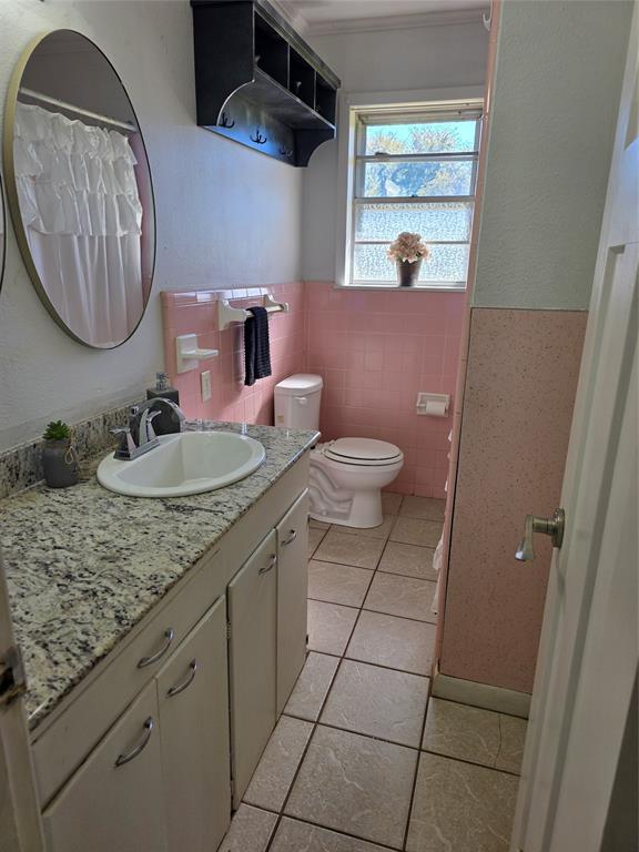 103 North Magnolia Street Plain Dealing, LA 71064 - Photo 18 of 26 Bathroom with vanity, light tile patterned floors, a shower with curtain, tile walls, and a textured wall
