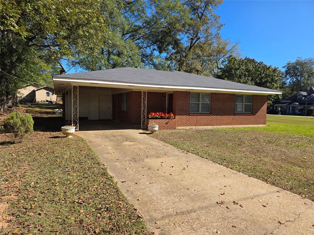 103 North Magnolia Street Plain Dealing, LA 71064 - Photo 2 of 26 a front view of a house with a yard and garage