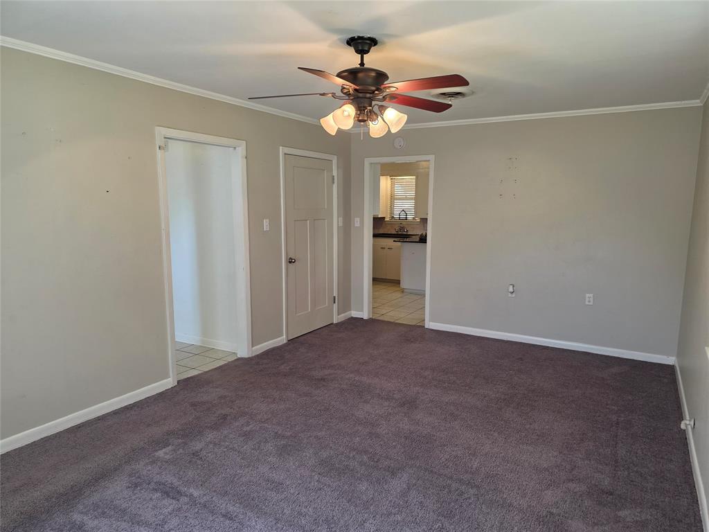 103 North Magnolia Street Plain Dealing, LA 71064 - Photo 22 of 26 Unfurnished bedroom featuring light carpet, ornamental molding, a closet, ceiling fan, and ensuite bath