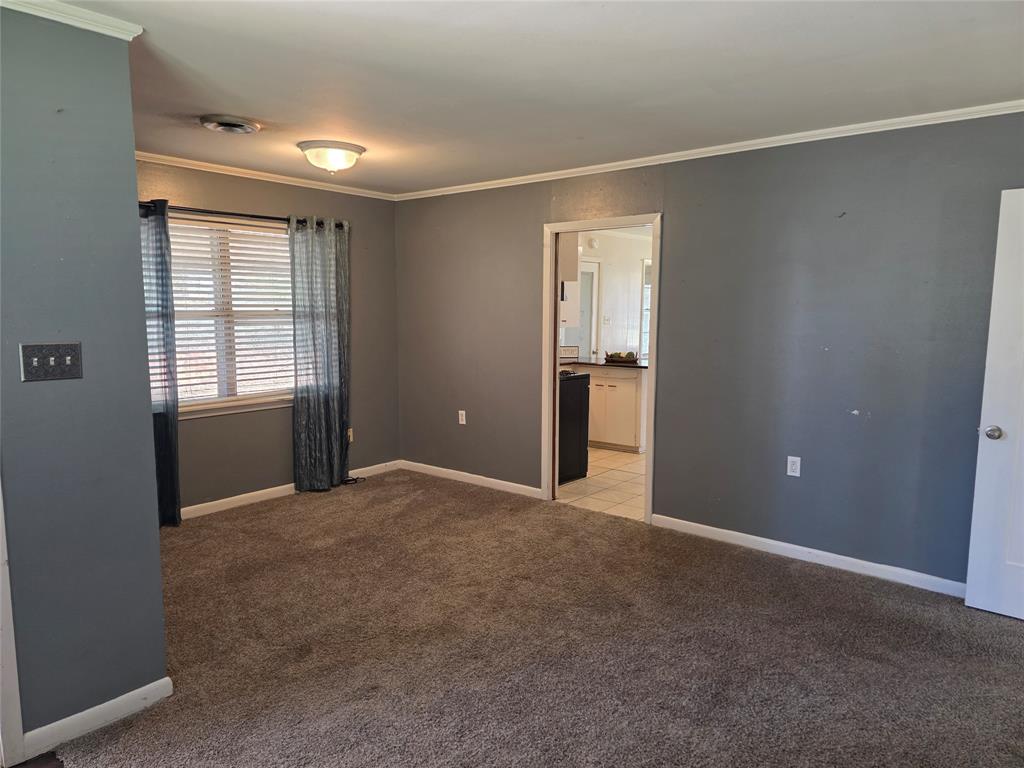 103 North Magnolia Street Plain Dealing, LA 71064 - Photo 7 of 26 Spare room with crown molding and light carpet