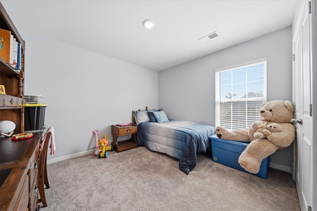 208 Grassy Creek Way Pendleton, SC 29670 - Photo 24 of 43 Comfortable bedroom with soft carpeting and ample natural light from the large window.