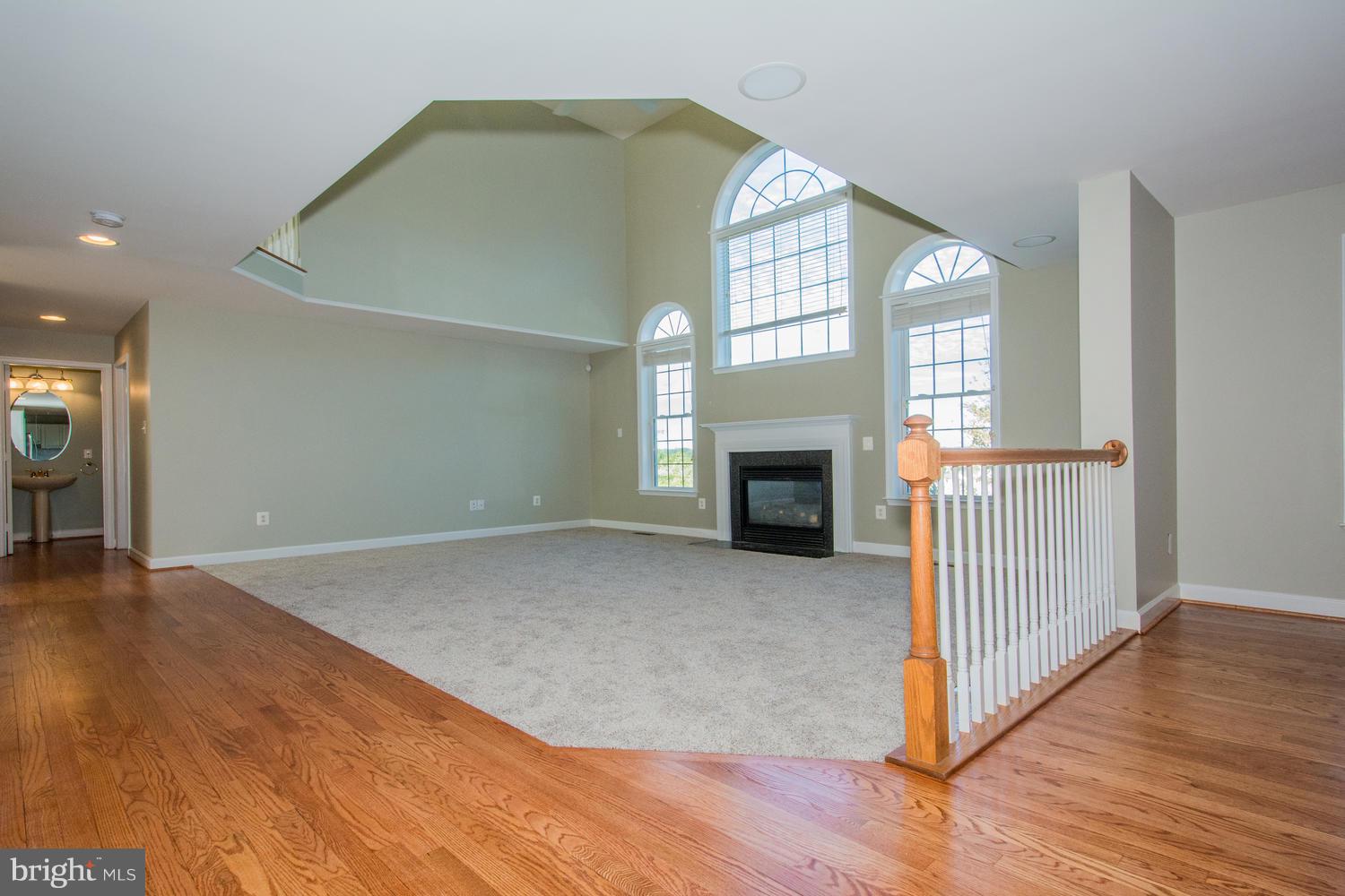 5986 Calvert Way Eldersburg, MD 21784 - Photo 12 of 40 an empty room with wooden floor fireplace and windows