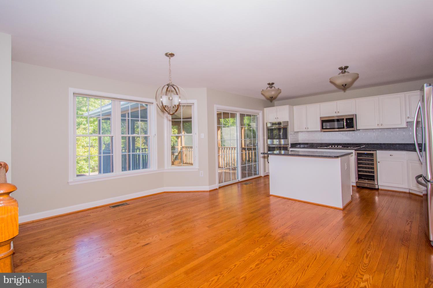 5986 Calvert Way Eldersburg, MD 21784 - Photo 3 of 40 a view of a kitchen with a sink wooden floor and windows