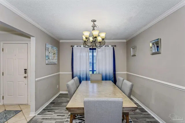 a dining room with wooden floor and chandelier