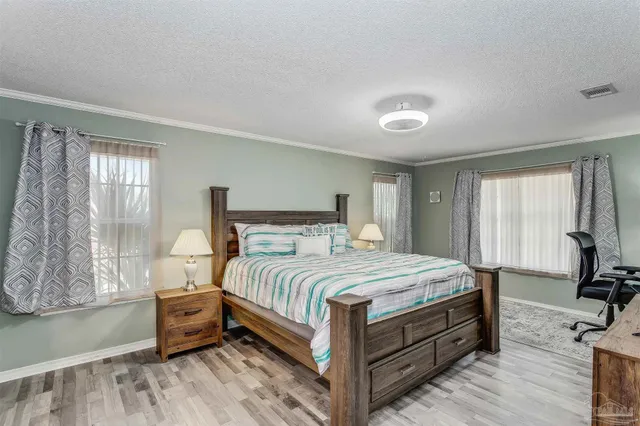 a bedroom with a bed and large windows