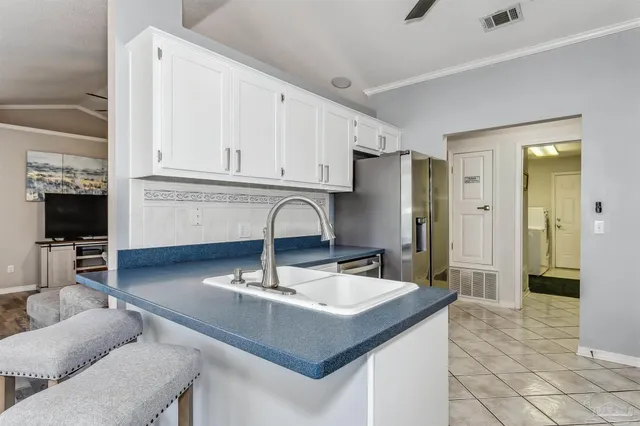a kitchen with stainless steel appliances a sink a stove a refrigerator and cabinets