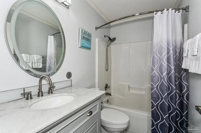 a bathroom with a granite countertop sink toilet a mirror and shower