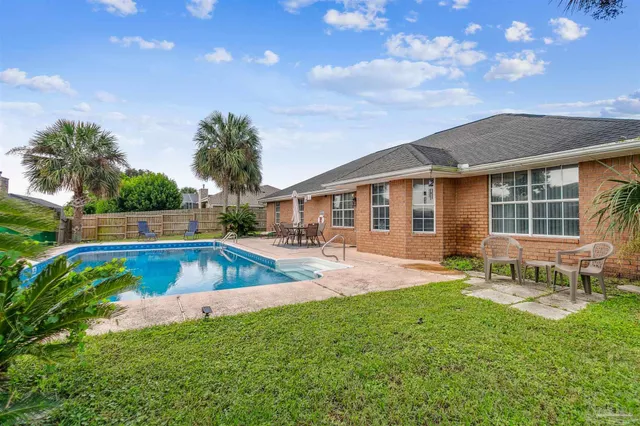 a view of a house with a backyard and a patio