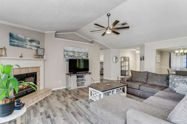 a living room with furniture a fireplace and a flat screen tv