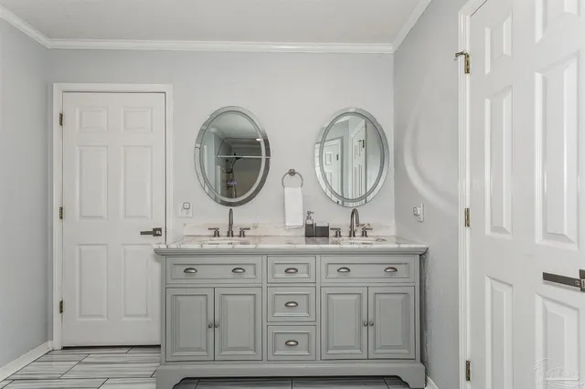 a bathroom with double vanity white and a mirror