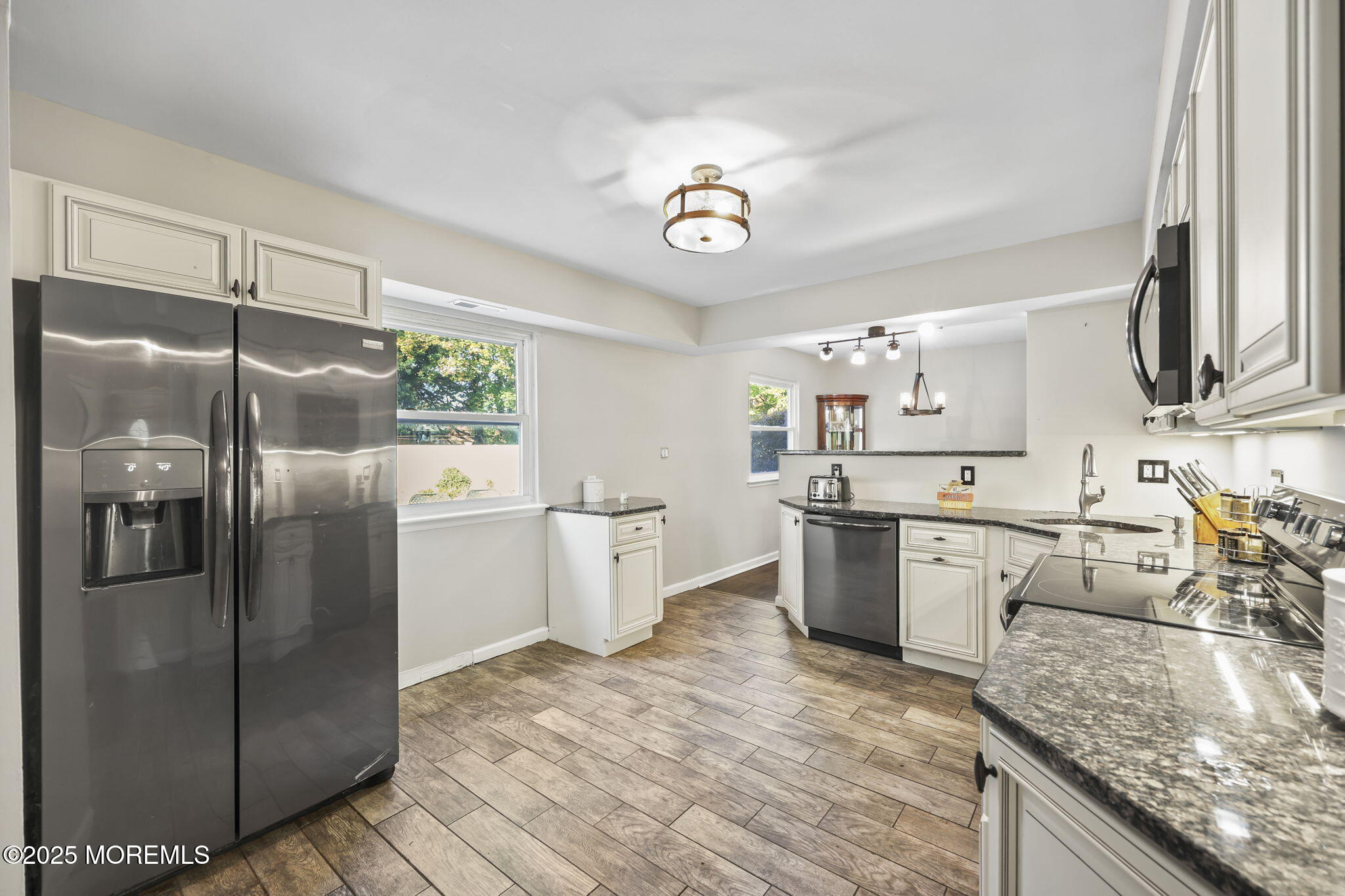 99 Glenarden Drive Howell, NJ 07731 - Photo 15 of 37 a kitchen with stainless steel appliances granite countertop a refrigerator a sink dishwasher a stove and white countertops with wooden floor