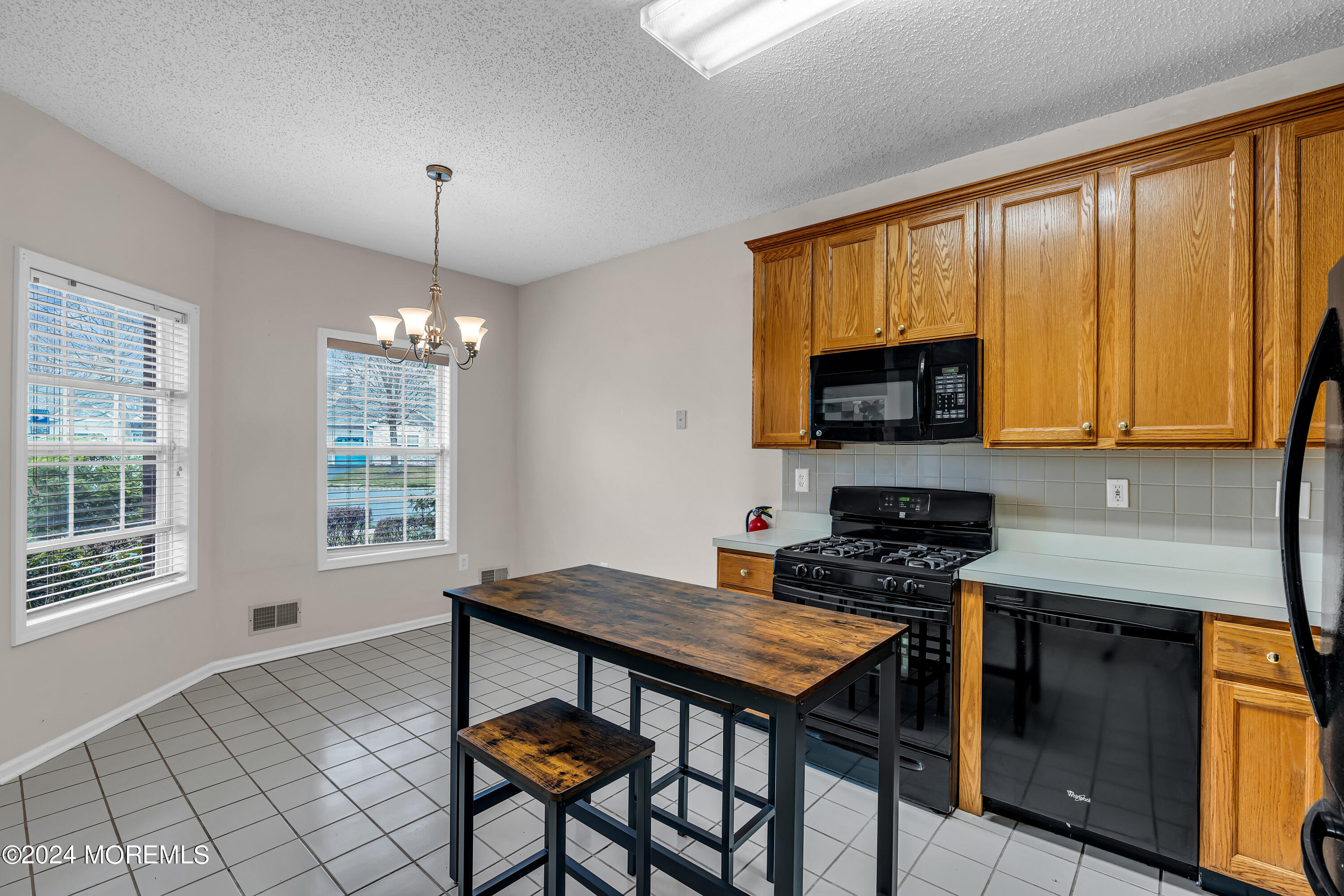 12 Riva Boulevard Brick, NJ 08723 - Photo 5 of 36 a kitchen with a stove a sink a microwave a dining table and chairs