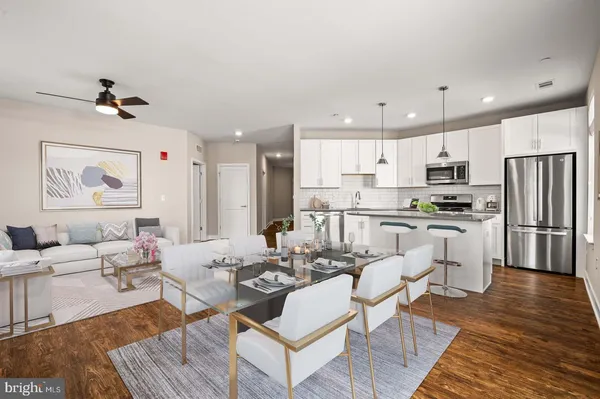 a living room with stainless steel appliances furniture and a view of kitchen