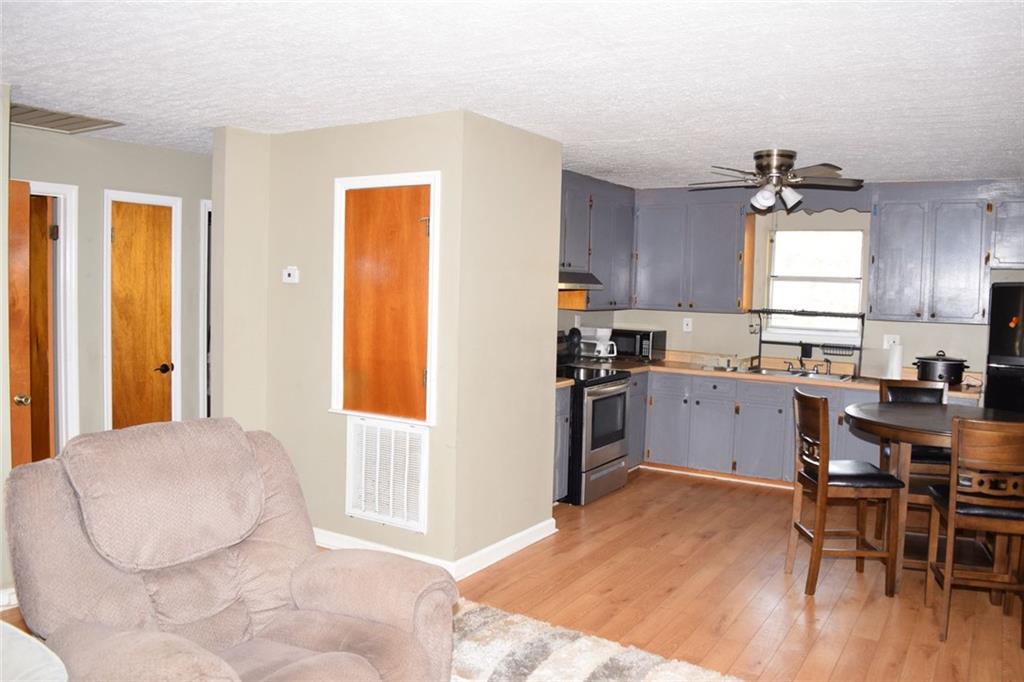 705 Triune Mill Road Thomaston, GA 30286 - Photo 18 of 34 a kitchen with a table chairs refrigerator and cabinets