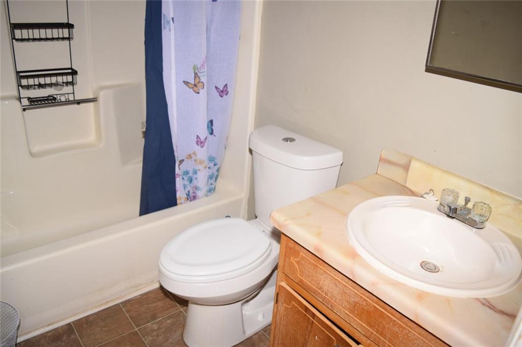 705 Triune Mill Road Thomaston, GA 30286 - Photo 21 of 34 a bathroom with a sink a toilet and shower curtain