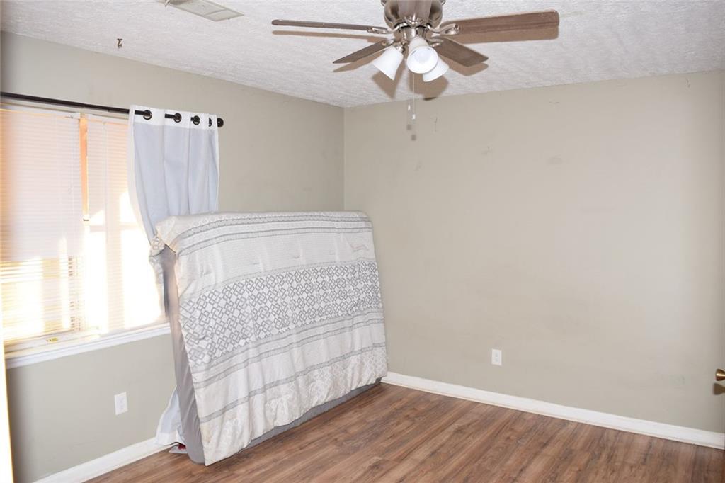 705 Triune Mill Road Thomaston, GA 30286 - Photo 23 of 34 an empty room with wooden floor fan and windows