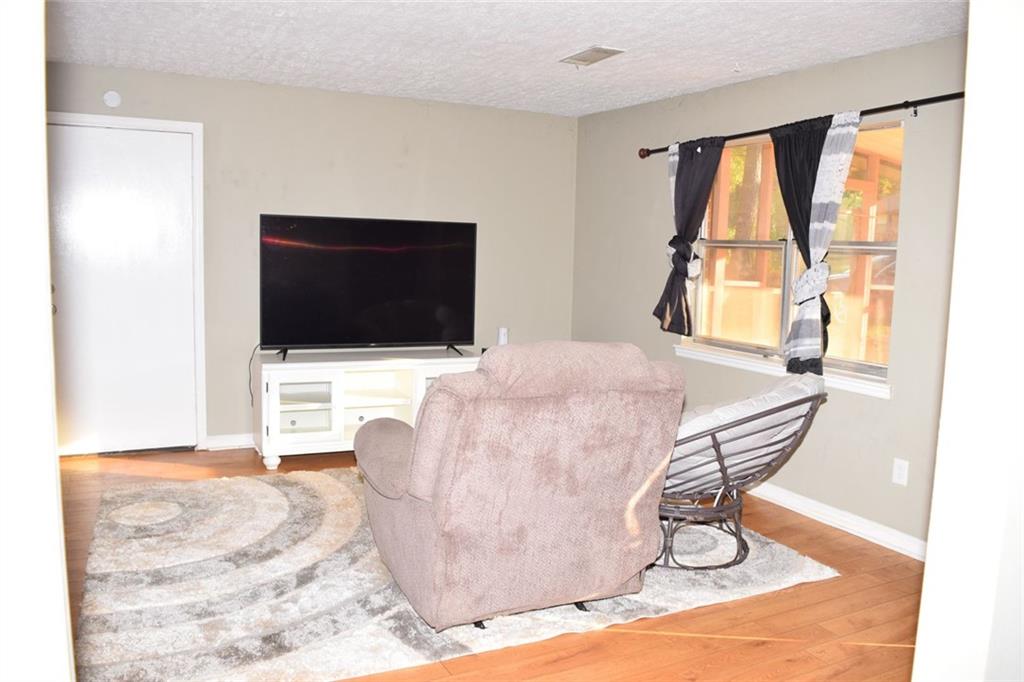 705 Triune Mill Road Thomaston, GA 30286 - Photo 6 of 34 a living room with a flat screen tv and a floor to ceiling window