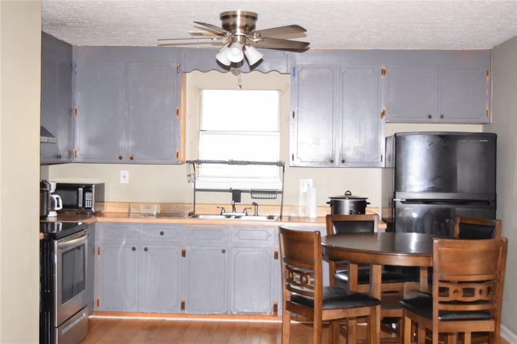 705 Triune Mill Road Thomaston, GA 30286 - Photo 9 of 34 a kitchen with stainless steel appliances a sink a stove a refrigerator cabinets and a window