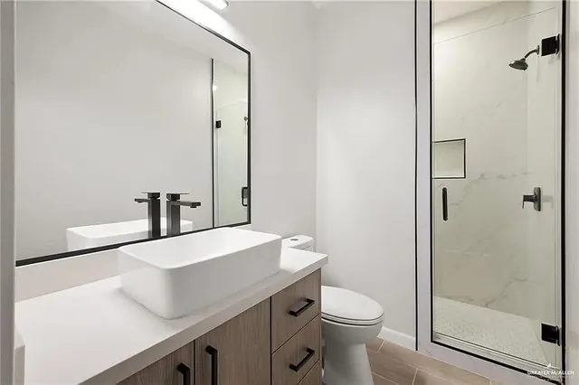 a bathroom with a sink a toilet and shower