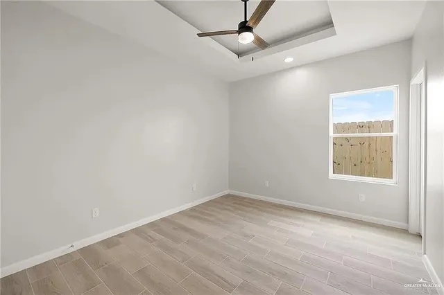an empty room with a window and ceiling fan