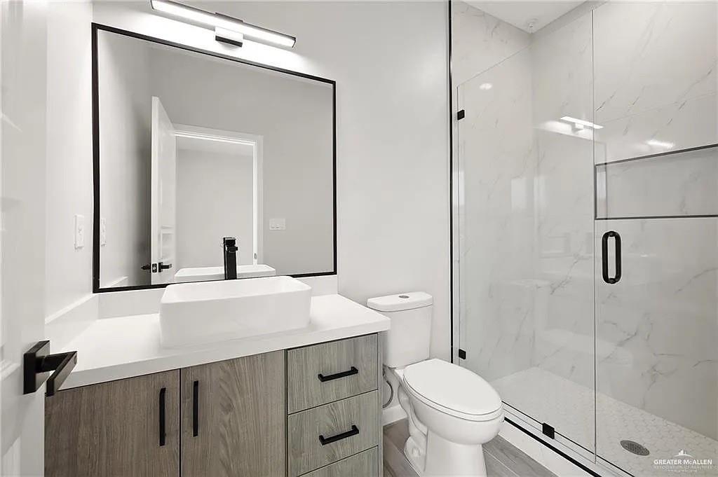 9206 North 56th Lane, Unit 4 Mission, TX 78573 - Photo 8 of 14 a bathroom with a sink toilet and shower