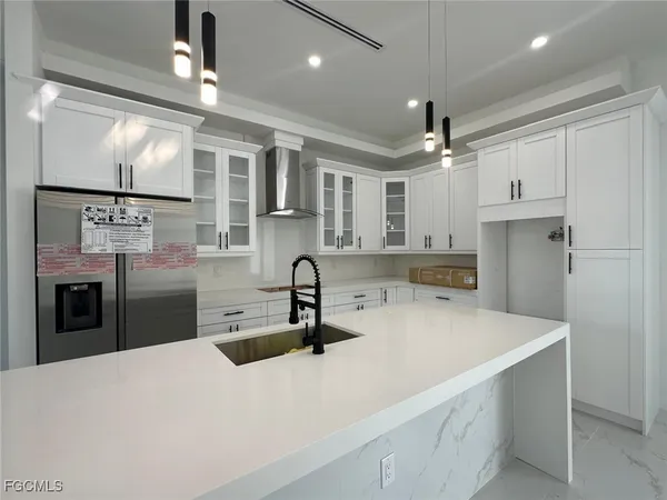 a kitchen with stainless steel appliances kitchen island a refrigerator sink and cabinets