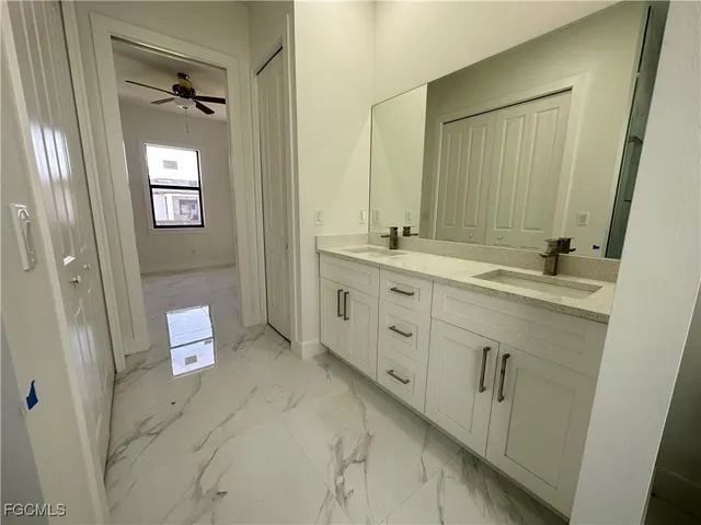 a spacious bathroom with a double vanity sink a mirror and a